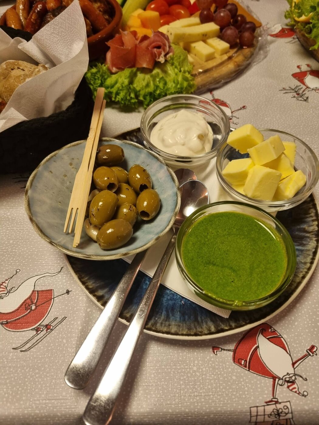 Oliven, dip, smør og grøn pesto sat frem til deling